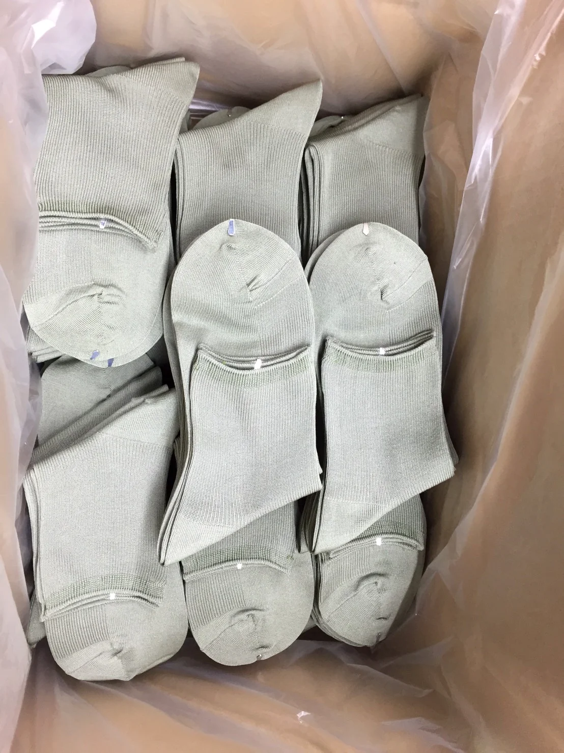 ひと組ずつたたまれ、爪先とゴム口を靴下の留め具（ソッパス）で留められた靴下が箱に並ぶ